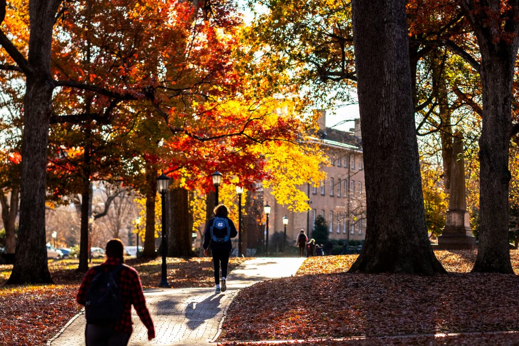 Students under fall leaves on the UNC-Chapel Hill campus