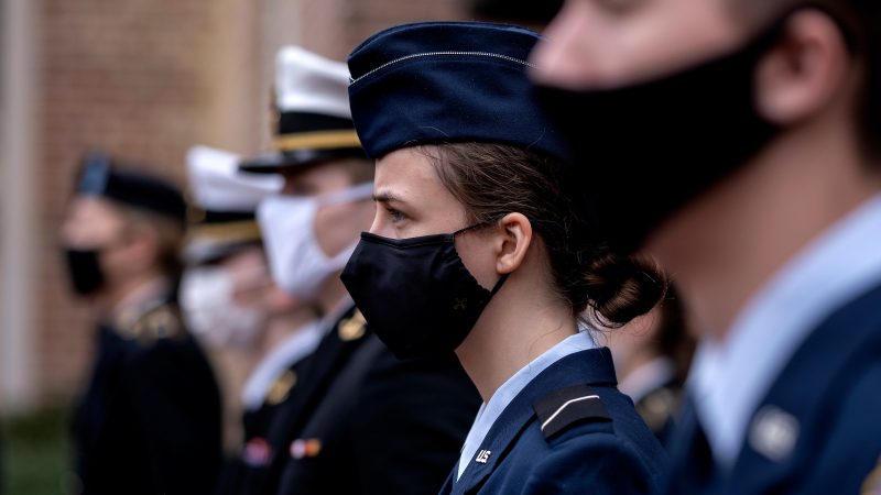 Students wearing military regalia and a mask