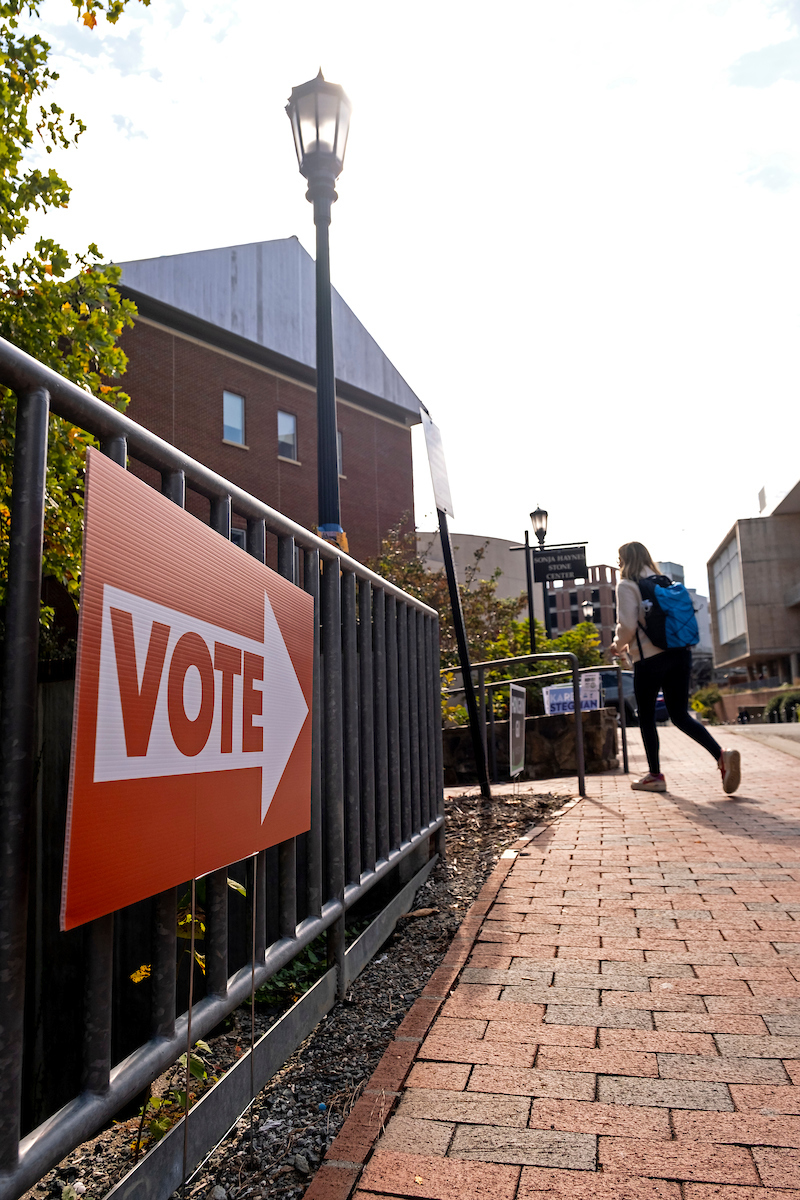 A student walks by a VOTE sign on campus